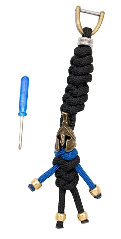 Llavero de paracord de Espartano E6036N, en color negro y azul con acabados en dorado, de 14 cm de largo. Contiene un destornillador para abrir el llavero, puede usarse para ponerse en cuchillos o navajas.